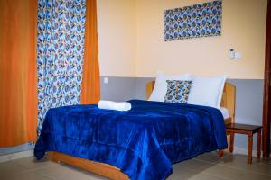 - une chambre avec un lit et une couverture bleue dans l'établissement Dreams House, à Libreville