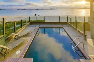a swimming pool with a view of the water at Mission Bay Dreams - w Bay Access, Parking, Pool & Spa in San Diego