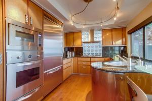 una cocina con electrodomésticos de acero inoxidable y armarios de madera en Mission Bay Dreams - w Bay Access, Parking, Pool & Spa, en San Diego
