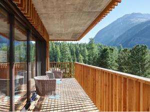 a balcony with chairs and a view of a mountain at Alpine Lodge Chesa al Parc in Pontresina