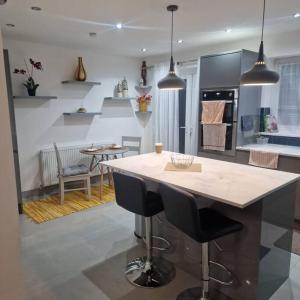 a kitchen with a large island with bar stools at 5 Bedroom Luxury Home with Garden in East London in Wanstead