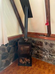 a stone fireplace with a stove in a room at The lookout Hideaway cabin in Baños