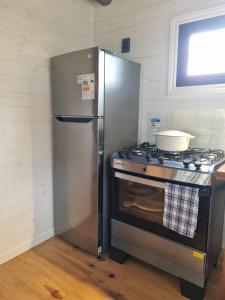 a kitchen with a stainless steel refrigerator and a stove at Juanillo's ll in Punta Del Diablo