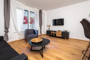 a living room with a couch and a table and a tv at Zoder Apartments in Vienna