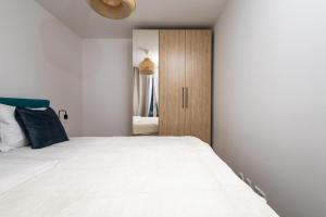 a bedroom with a white bed and a wooden cabinet at Zoder Apartments in Vienna