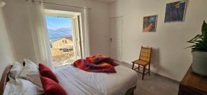 a bedroom with a bed and a large window at T2 typique au cœur du village et vue sur le Golfe in Olmeto