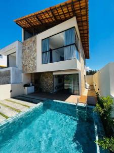 uma casa com piscina em frente a uma casa em Casa Flora Patacho em Pôrto de Pedras