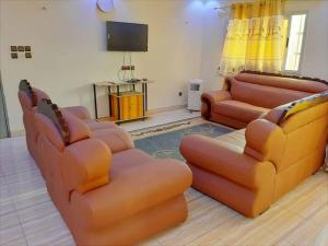 sala de estar con 2 sofás y TV de pantalla plana en Villa pour vos vacances à Lomé, en Agouévé
