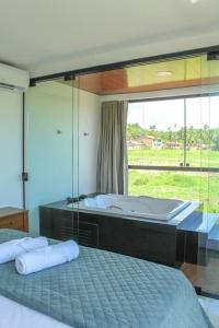 1 dormitorio con espejo grande y bañera en Casa Flora Patacho en Pôrto de Pedras