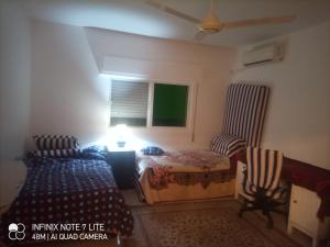 1 dormitorio con 2 camas y ventana en شقق مدن الديكابوليس en Irbid