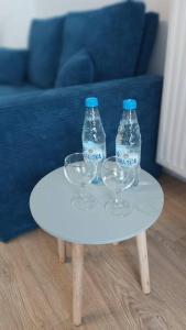 dwie butelki wody i dwa kieliszki wina na stole w obiekcie Życzliwy Apartament z garażem w Warszawie