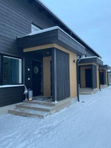 a house with a porch in the snow at Nordic Wooden House 3 in Rovaniemi