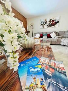 a living room with a table with magazines on it at Vintage Family Scape + heated pool&discount in Tampa