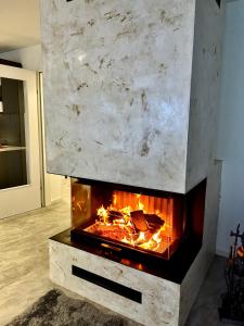 una chimenea de piedra en una sala de estar con llamas en My Appartements en Untertauern