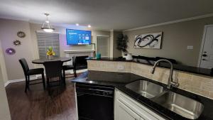 a kitchen with a sink and a table with chairs at Med Center Charm 2br Haven in Houston