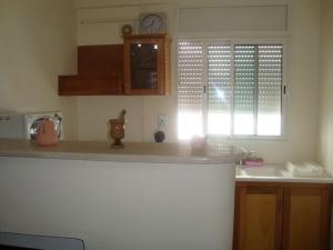 uma cozinha com um lavatório e um relógio na parede em JARDIN Apartments em El Aouina