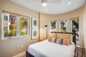 een slaapkamer met een bed en 3 ramen bij Massive Dream Beach Home - Dog Friendly, AC, Steps2Sand in San Diego