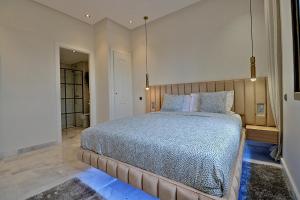 een slaapkamer met een groot bed in een kamer bij AeroSuite in Nouaceur