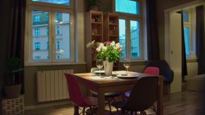 una mesa de comedor con sillas y un jarrón de flores en Luxury beautiful spacious apartment in perfect location en Praga