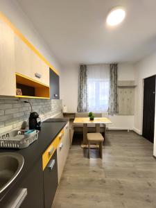 Una cocina con un fregadero y una mesa dentro. en Salt Mine Retreat - Free Parking, en Turda