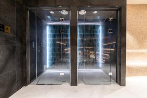 two glass elevator doors in a building at KOPAONIK WOODSIDE 58,70 m2 FREE Parking in Kopaonik