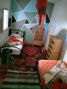 1 dormitorio con 2 camas y pared geométrica en Ocean Jam Surf House, en Agadir