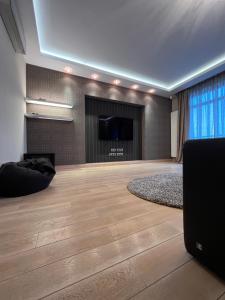 ein großes Wohnzimmer mit einem Flachbild-TV und ein großes Zimmer in der Unterkunft Apartment on Arkhipenka with Panorama View in Lwiw