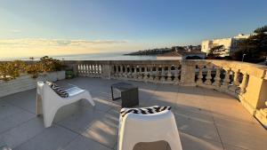 een patio met stoelen en uitzicht op de oceaan bij Appartement vue mer à Pontaillac in Royan