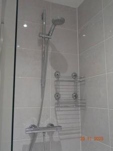 La salle de bains est pourvue d'une douche et d'une porte en verre. dans l'établissement Beautiful 4 bed house in Leeds, à Cross Gates