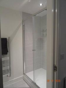 La salle de bains est pourvue d'une douche avec une porte en verre. dans l'établissement Beautiful 4 bed house in Leeds, à Cross Gates