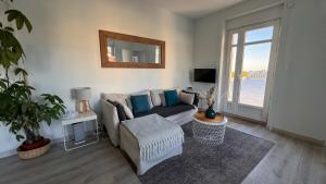a living room with a couch and a mirror at Appartement vue mer à Pontaillac in Royan