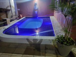 a bath tub with blue lighting in a bathroom at Pousada Saruê Natal Praia RN in Natal