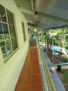 uma varanda de uma casa com um pátio com um guarda-chuva em Hostal Ebenezer em Palmilla