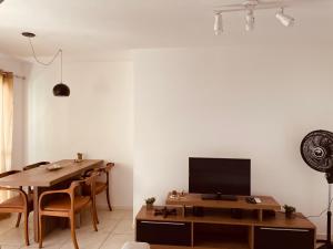 a living room with a table and a television at Apartamento JTR Maceió in Maceió