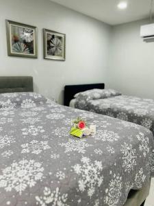 2 Betten in einem Hotelzimmer mit Blumen auf dem Bett in der Unterkunft Grey Novo Studio + free-parking&wifi in Tampa