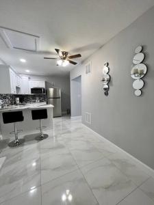 a living room with a ceiling fan and a kitchen at Grey Novo Studio + free-parking&wifi in Tampa