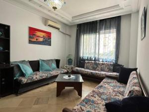 a living room with two couches and a coffee table at JARDIN Apartments in El Aouina