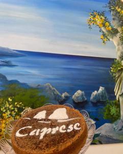 a cake sitting on a table in front of a painting at La Bella Annacapri in Anacapri