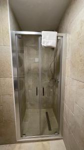 una doccia con una porta in vetro in un bagno di Les Comtes de Savoie - Appartement rénové proche du centre de Megève avec vue sur le Mont d'Arbois a Megève Altre 15 foto