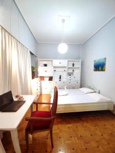 a bedroom with a bed and a desk and a laptop at Charm & Comfort near Petralona station in Athens