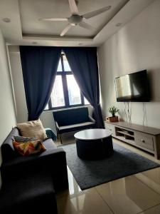 Una sala de estar con un sofá y un televisor. en Legasi Kampung Baru apartment by rumahrehat, en Kuala Lumpur