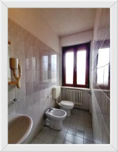 een badkamer met een toilet, een bad en een wastafel bij HOTEL RISTORANTE DELLE VALLI in Germagnano