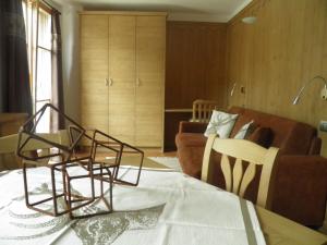 ボルミオにあるAppartamento Zeppのリビングルーム(ソファ、テーブル、椅子付)