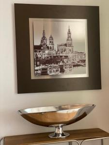 un tazón en una mesa con una foto en la pared en Villa am Grossen Garten en Dresden