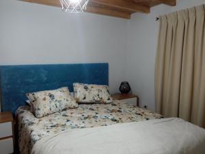 um quarto com uma cama com uma cabeceira azul em Casa Tia Vina em Arouca