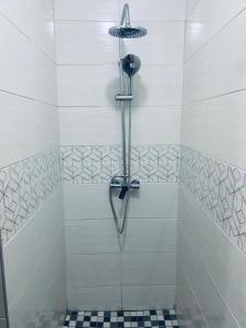 a shower with a shower head in a bathroom at AfrikaWisa at O.R. Tambo International Airport in Kempton Park