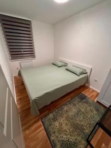 a bedroom with a bed in a room with a rug at Pale Green in Pale