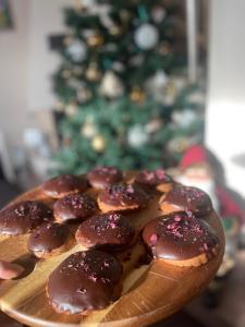 a plate of chocolate covered cookies with a christmas tree in the background at Sarenka in Białka Tatrzańska