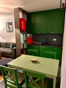 a kitchen with green cabinets and a table and chairs at Pale Green in Pale