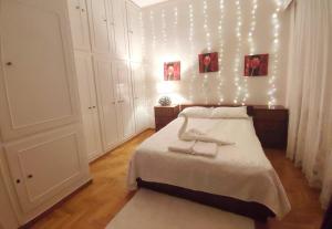 a bedroom with a bed with lights on the wall at Charm & Comfort near Petralona station in Athens